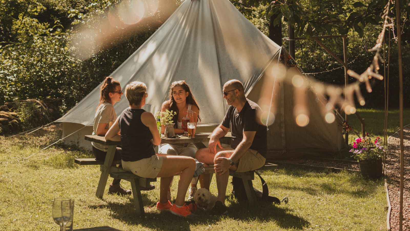 Image of friends socialising outside of a bell tent